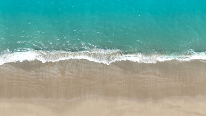 Tropical Beach with the soft wave water of the sea on the sandy beach background as texture with splashes