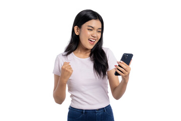 Fototapeta premium Excited young Asian woman celebrating victory while looking at her smartphone, isolated on transparent background