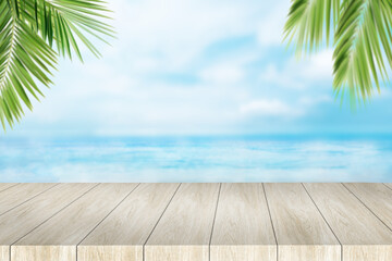 A wooden table with a view of the ocean and palm leaves. Template for product