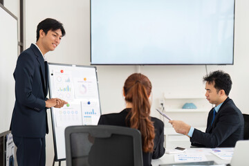 Professional Engagement and Strategic Discussion. An enthusiastic presenter working with colleagues, focusing on project performance metrics.