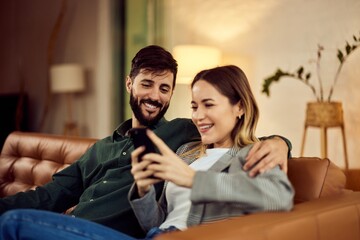 Couple Enjoying Smartphone Together in Cozy Living Room Setting