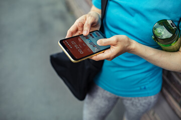 Woman checking fitness app stats on smartphone after workout