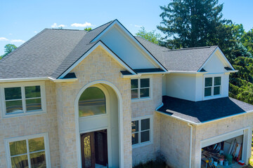 Beautiful house features grand entrance with large windows, surrounded by lush greenery