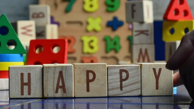 Wooden blocks arranged to form the word HAPPY on a simple background. Creative typography concept symbolizing positivity, motivation, joy, happiness, emotional expression, inspiration, and cheerful li