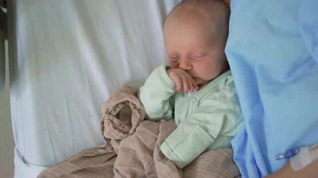 A cute newborn baby sleeps peacefully on a clinic bed beside their mother. A serene and heartwarming moment capturing rest, bonding, and the start of a new life in a medical setting.