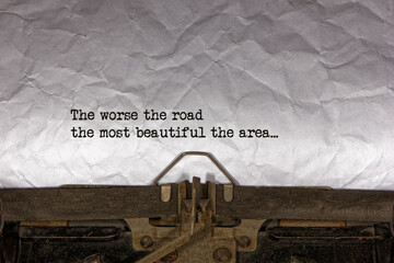 The worse the road the most beautiful the area close up of a phrase being typed and centered on a...