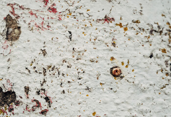 A wall with a hole in it and a red and white paint splatter