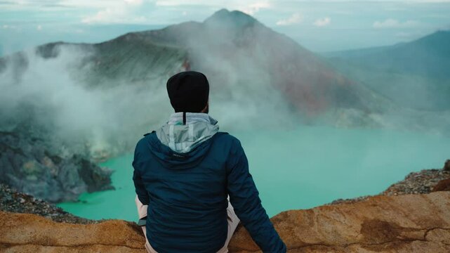 Man enyoing Misty Volcano of Kawah Ijen crater in East Java