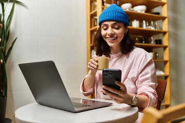 Fototapeta premium Young woman enjoys remote work in modern cafe while sipping coffee