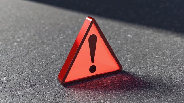 A red triangular warning sign sits on top of a table, alerting to potential danger
