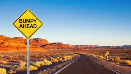 A yellow warning sign with 'Bumppy Ahead' text on a road, advising drivers of potential hazards