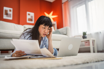 Fototapeta premium confuse mature japanese woman work laptop and analysis documents