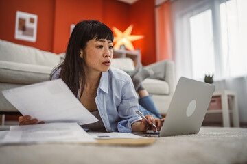 confuse mature japanese woman work laptop and analysis documents