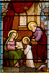 Stained glass (19th century) of the young Virgin Mary with her parents Saint Anne and Saint Joachim.