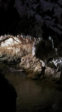 The bright and colorful Abrskil cave. A gallery-type cave in the mountains of Abkhazia with many stalactites and stalagmites, colorful lighting. Otapskaya (Otap cave). 4K