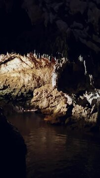 The bright and colorful Abrskil cave. A gallery-type cave in the mountains of Abkhazia with many stalactites and stalagmites, colorful lighting. Otapskaya (Otap cave). 4K	