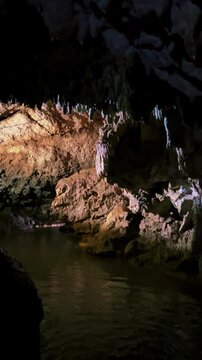 The bright and colorful Abrskil cave. A gallery-type cave in the mountains of Abkhazia with many stalactites and stalagmites, colorful lighting. Otapskaya (Otap cave). 4K
