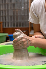 The process of kneading and manufacturing artisanal ceramics and clay by hand and with a wheel, showing the step-by-step process by the hands of a ceramics professional.
