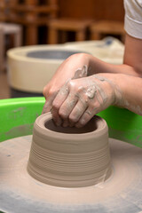 The process of kneading and manufacturing artisanal ceramics and clay by hand and with a wheel, showing the step-by-step process by the hands of a ceramics professional.
