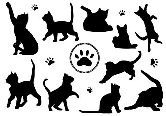 Silhouettes of playful cats in various poses on a white background for textile and design use