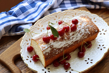 Sponge cake with cherry on old wooden background. Biscuit with summer fruit