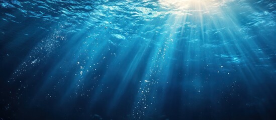 Underwater sunbeams illuminate ocean depths, background bubbles; marine backdrop