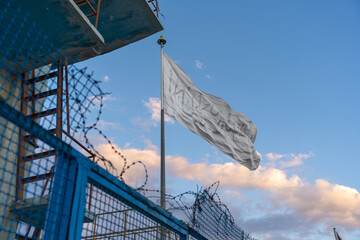 the national flag of Afghanistan behind a metal fence and barbed wire