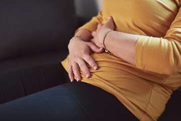 Woman with strong stomach ache, menstrual and digestive issues at home.