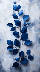 Slender Branch with Vibrant Blue Leaves Against a Textured Muted Blue and Gray Background