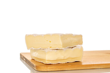Pieces of fragrant brie cheese on a bamboo cutting board isolated on a white background, close-up.