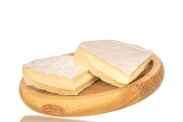 Pieces of fragrant brie cheese on a wooden plate isolated on a white background, close-up.