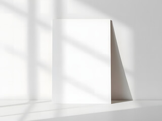 Fototapeta premium Blank Canvas of Possibilities: A minimalist composition showcasing a blank white poster leaning against a wall, adorned by the play of light and shadow.