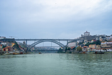 Obraz premium Scenic view of Dom Luis I Bridge from a Douro River cruise. See Porto and Vila Nova de Gaia's colorful riverside architecture.
