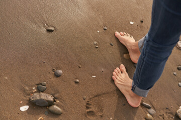 Tranquil Moments by the Shoreline With Bare Feet Touching Soft Sand at Sunset