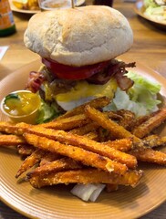 homemade cheeseburger with bacon and sweet potato fries and dip