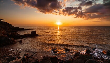 golden sunset over rocky ocean shore with dramatic clouds and sun rays reflecting on water for travel, nature, and meditation themes

