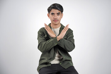 Handsome Asian man with hand gesture pose rejection or prohibition with copy space.