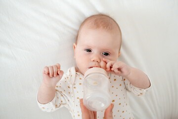 Mom's hand holds a bottle of milk for a newborn baby. Small child with bottle close-up, High quality 4k footage