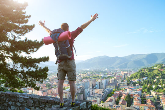 young traveler standing with open arms on the city landscape