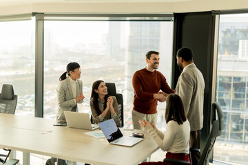 Fototapeta premium Team collaborates in modern office setting on innovative project with laptops and discussion