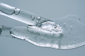 Pipette with serum on a blue background. Product texture.