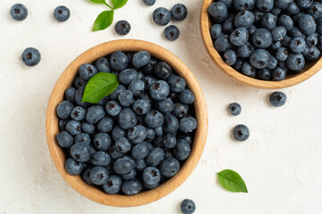 Bowl with fresh bright blueberries on concrete background,top view