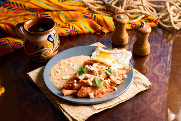 Delicious chilaquiles with fried egg and refried beans for authentic mexican breakfast