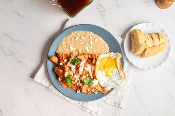 Traditional Mexican chilaquiles with red sauce, authentic mexican breakfast