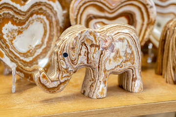 Elephant made of onyx. Elephant statue made of natural onyx stone stands on display case of souvenir shop. Close-up of elephant figure made of onyx. Detailed Close-up reveals mineral patterns of onyx.