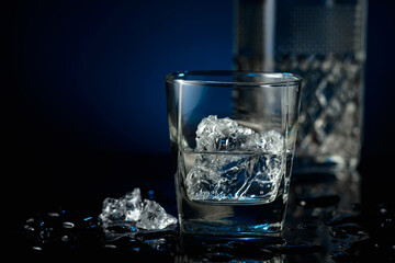 Crystal clear vodka or gin in a glass with ice.
