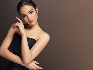 Asian woman in a black top   . Beautiful  Asia girl stands in a graceful pose.Korean, Japanese and Chinese cosmetics, makeup and fashion