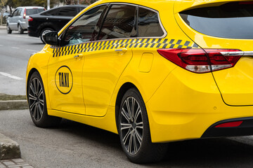 Yellow taxi car on street in Europe. A bright yellow taxi cab parked on urban city street.