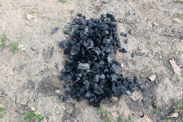 A pile of charcoal from a fire on the ground