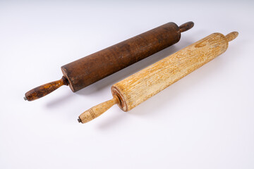 old bakers rolling pins lined on an angle with white surface